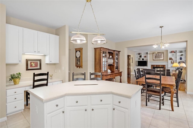 kitchen featuring hanging light fixtures, a kitchen island, and white cabinets