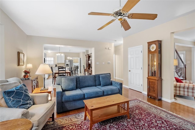 living room with dark wood-type flooring and ceiling fan with notable chandelier