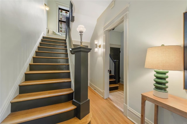 staircase with hardwood / wood-style floors