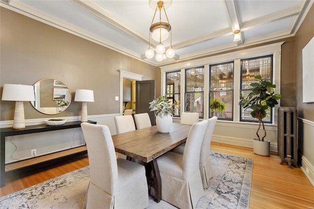 dining area featuring radiator, crown molding, light hardwood / wood-style flooring, and coffered ceiling