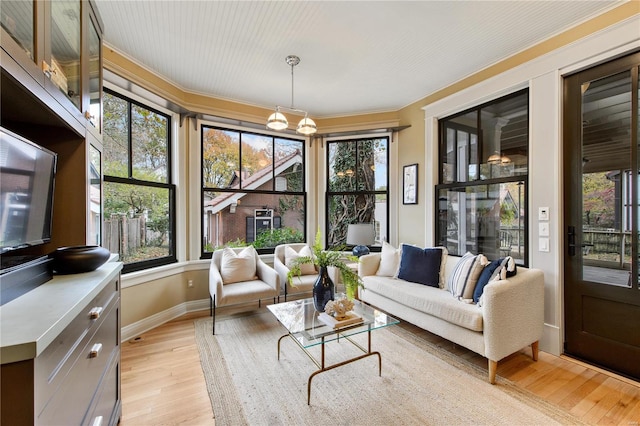 sunroom featuring a chandelier and plenty of natural light