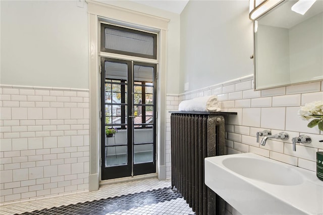 bathroom featuring french doors, sink, tile patterned flooring, tile walls, and radiator heating unit