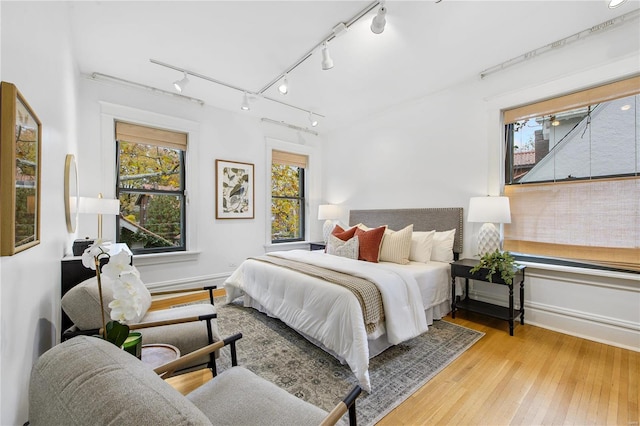 bedroom with light hardwood / wood-style floors and rail lighting