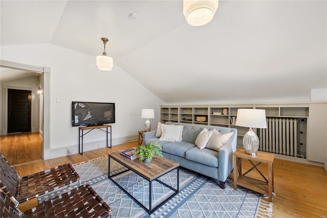 living room featuring radiator heating unit, vaulted ceiling, and hardwood / wood-style flooring