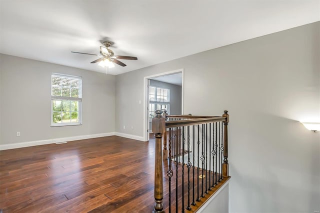 interior space with ceiling fan and dark hardwood / wood-style flooring