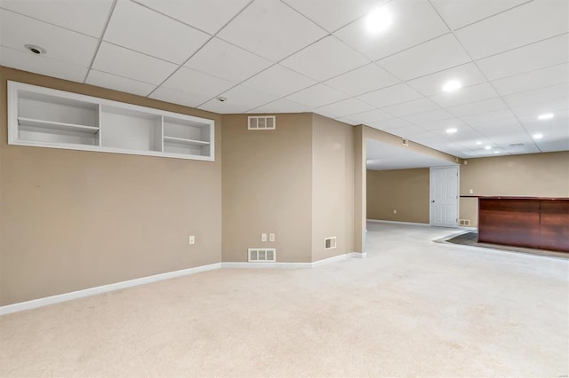 basement featuring carpet floors and a paneled ceiling