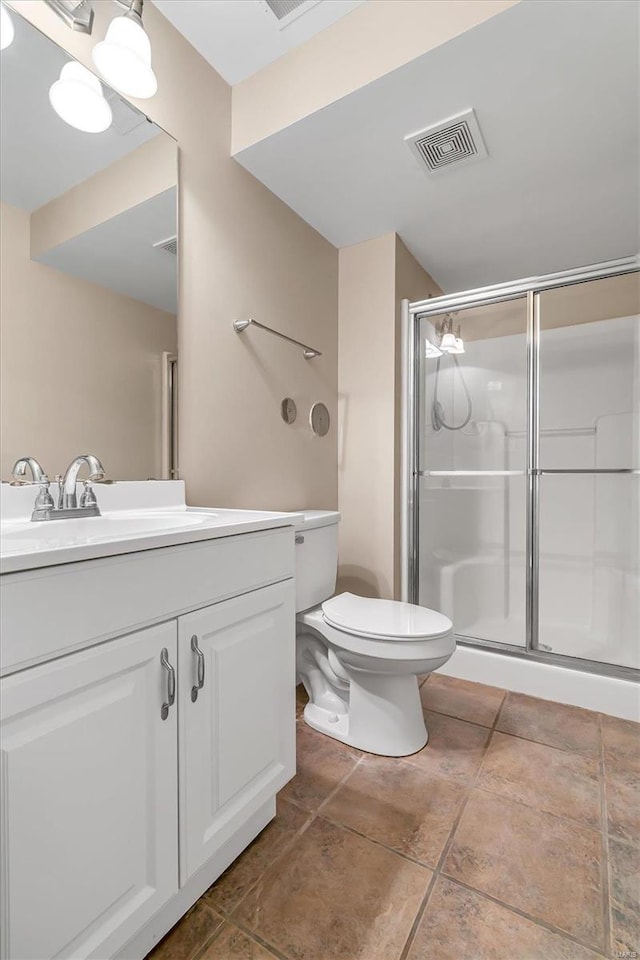 bathroom featuring vanity, a shower with shower door, toilet, and tile patterned flooring