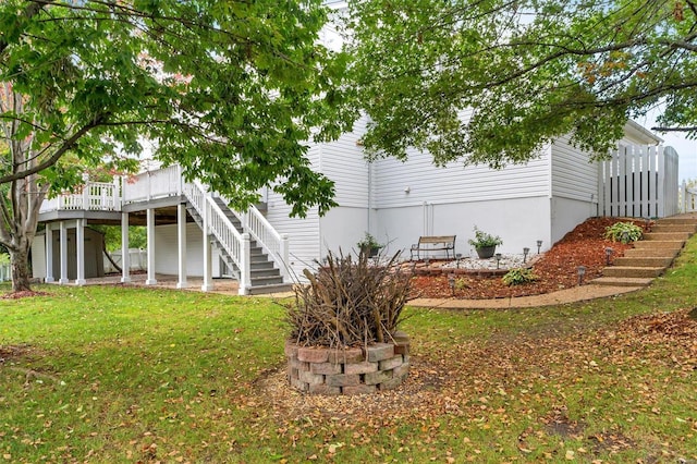 back of house with a deck and a lawn