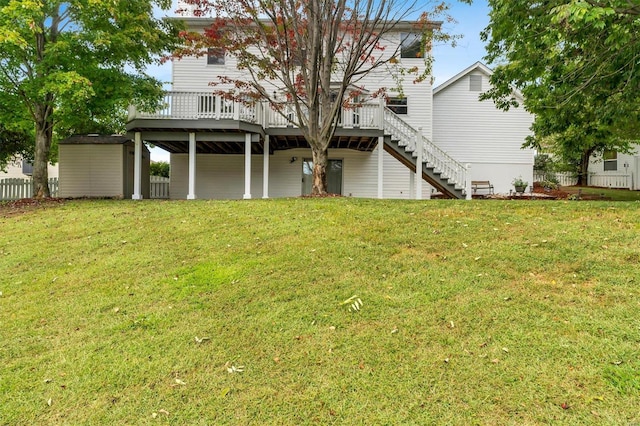 rear view of house featuring a lawn and a wooden deck