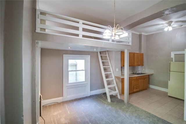 kitchen featuring pendant lighting, sink, ceiling fan with notable chandelier, light colored carpet, and white fridge