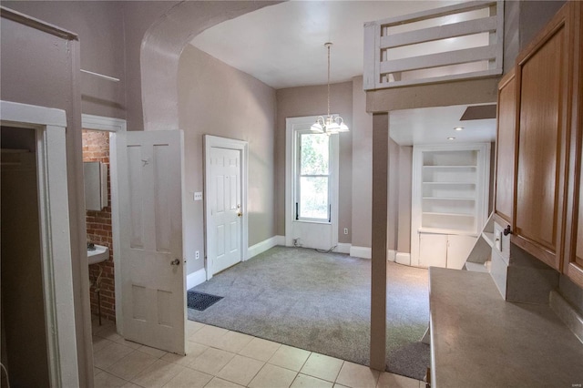 tiled entryway with a notable chandelier