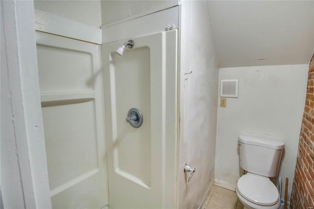 bathroom with lofted ceiling, tile patterned flooring, and toilet