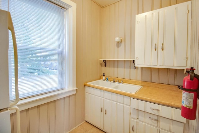 kitchen featuring white cabinetry, sink, and light tile patterned floors