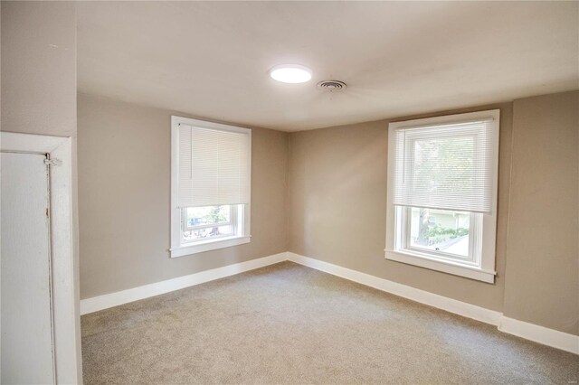 carpeted spare room with a healthy amount of sunlight