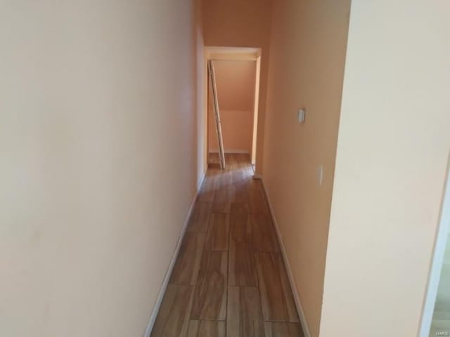 hallway featuring wood finished floors and baseboards