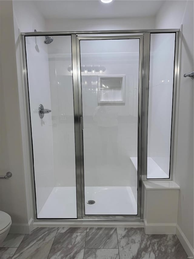 bathroom with toilet and an enclosed shower