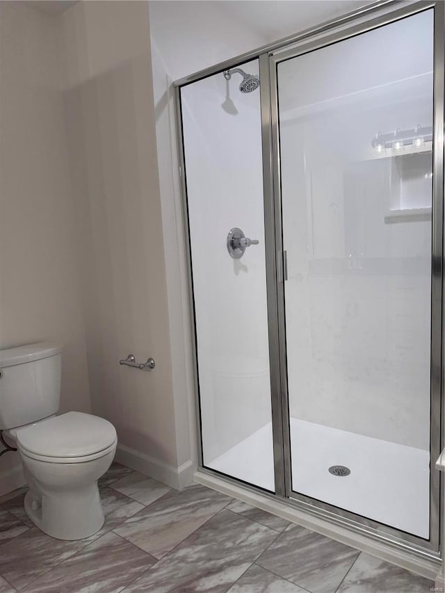 bathroom featuring toilet and a shower with door