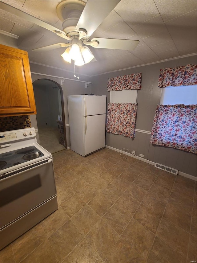 kitchen featuring white refrigerator, ornamental molding, range, and ceiling fan