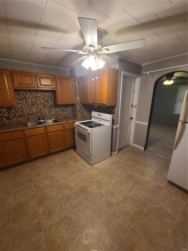 kitchen featuring ceiling fan, sink, white appliances, backsplash, and crown molding