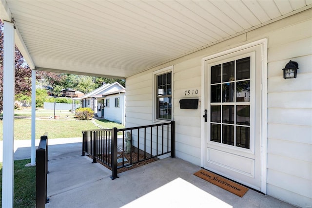 doorway to property featuring a yard and a porch