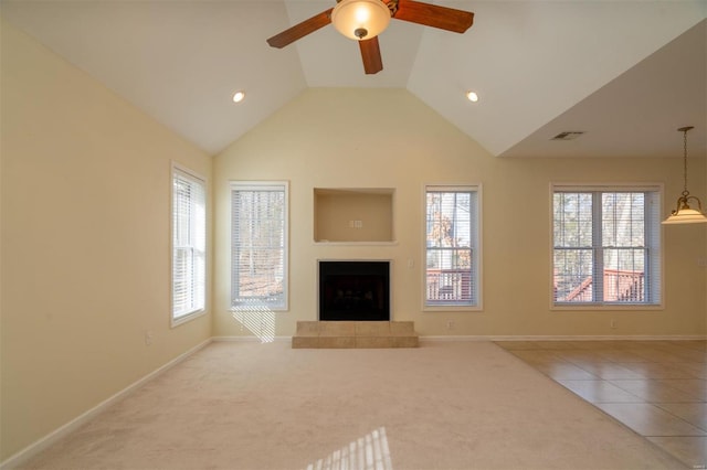 unfurnished living room with a tile fireplace, lofted ceiling, ceiling fan, and tile patterned floors