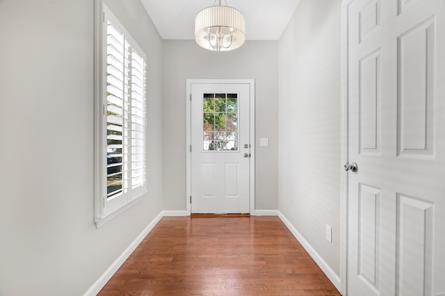 entryway with a chandelier and dark wood-type flooring