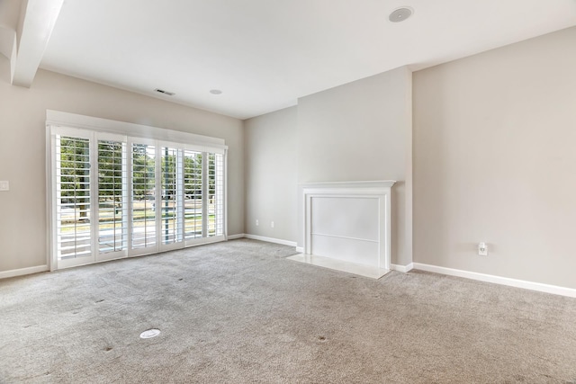 unfurnished living room featuring light colored carpet and beam ceiling