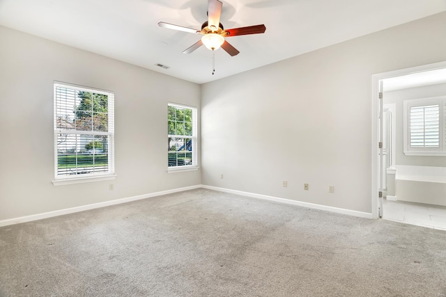 carpeted spare room featuring ceiling fan