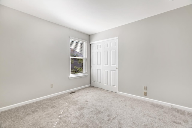 unfurnished room featuring light colored carpet