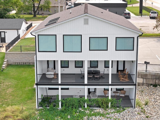 rear view of house featuring a yard and a balcony