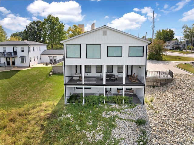 rear view of property with a yard and a balcony