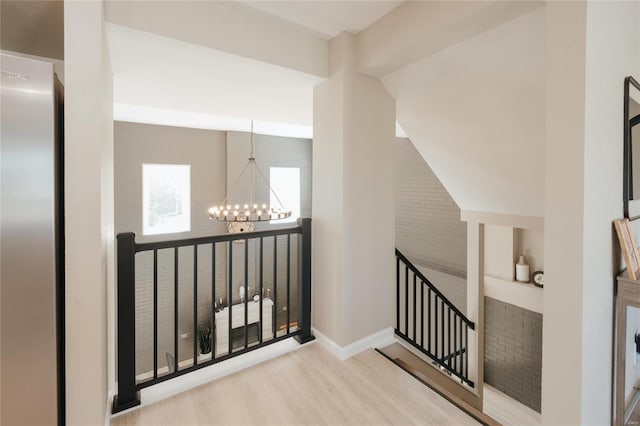 hallway featuring light hardwood / wood-style flooring and an inviting chandelier