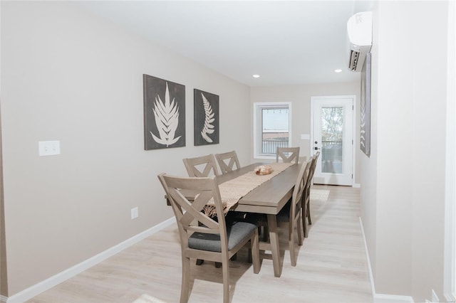 dining room featuring an AC wall unit and light wood-type flooring