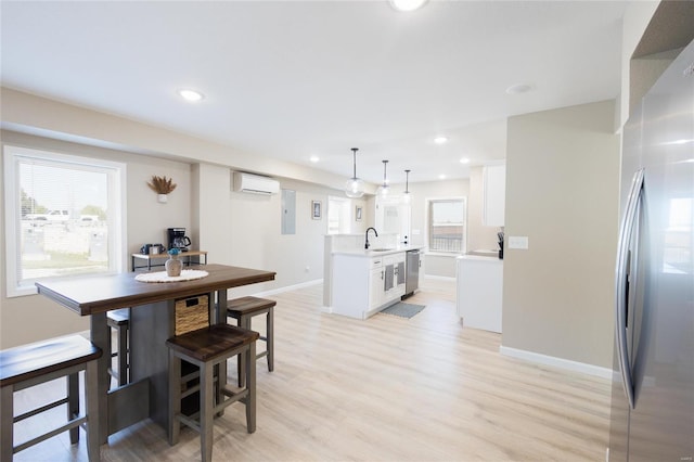 dining space featuring light hardwood / wood-style flooring, sink, and a wealth of natural light