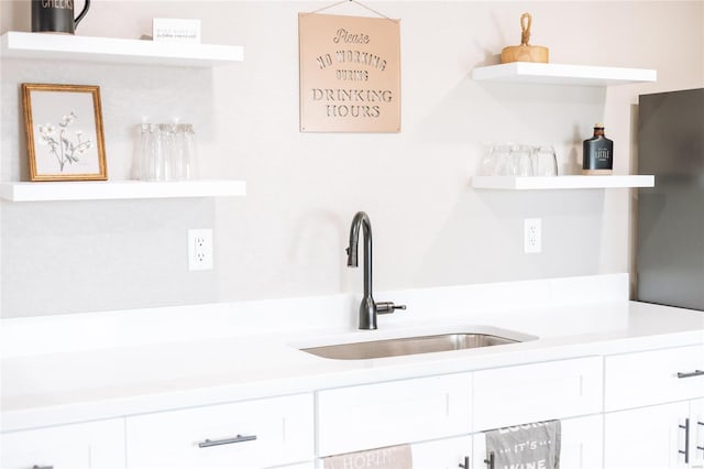 kitchen featuring white cabinetry and sink