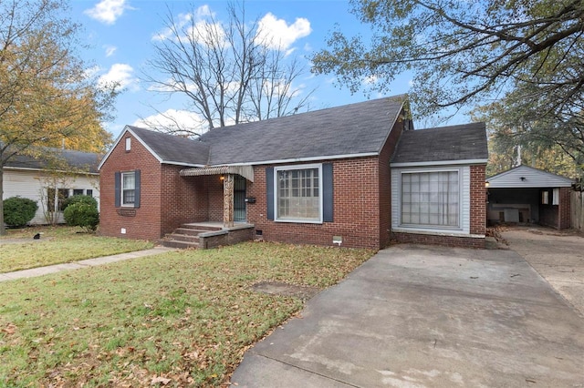 bungalow-style home with a front lawn and an outdoor structure