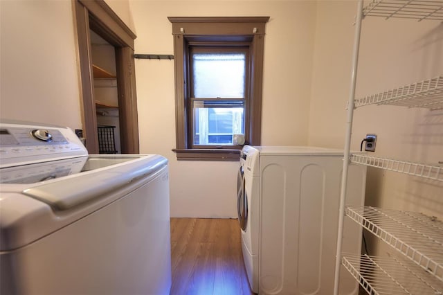 laundry room with washing machine and dryer and hardwood / wood-style flooring