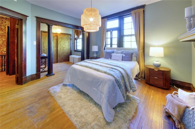 bedroom with light hardwood / wood-style floors and a notable chandelier