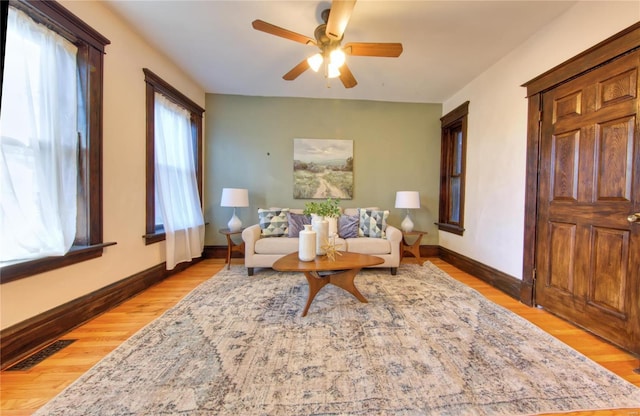 living area featuring light wood-type flooring and ceiling fan