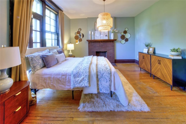 bedroom with hardwood / wood-style floors and a fireplace