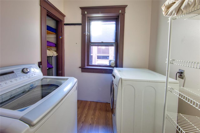 clothes washing area with washer and clothes dryer and dark hardwood / wood-style flooring