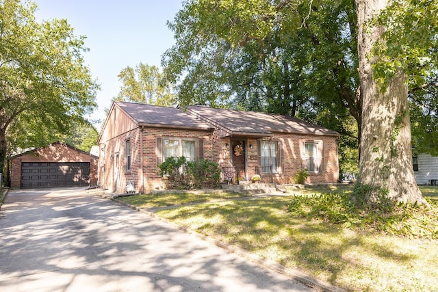 view of front of home featuring a garage, a front yard, and an outdoor structure