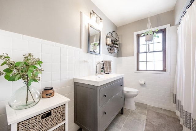 bathroom with toilet, vanity, and tile walls