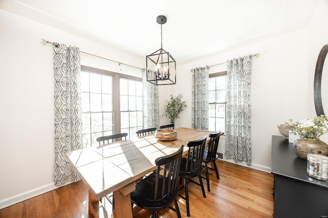 dining area featuring light hardwood / wood-style floors and an inviting chandelier