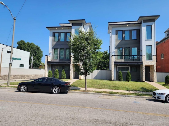 modern home with a balcony and a front lawn