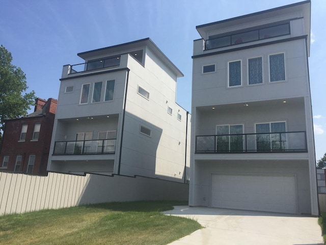 rear view of property with a balcony and a garage