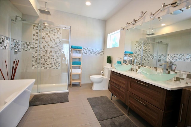 full bathroom featuring tile walls, vanity, tile patterned flooring, plus walk in shower, and toilet