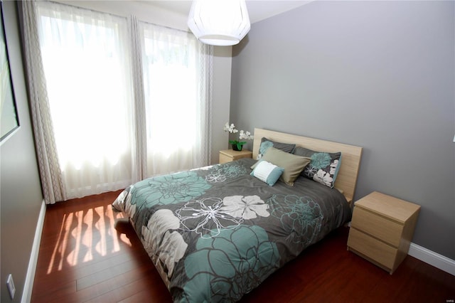 bedroom with dark hardwood / wood-style floors