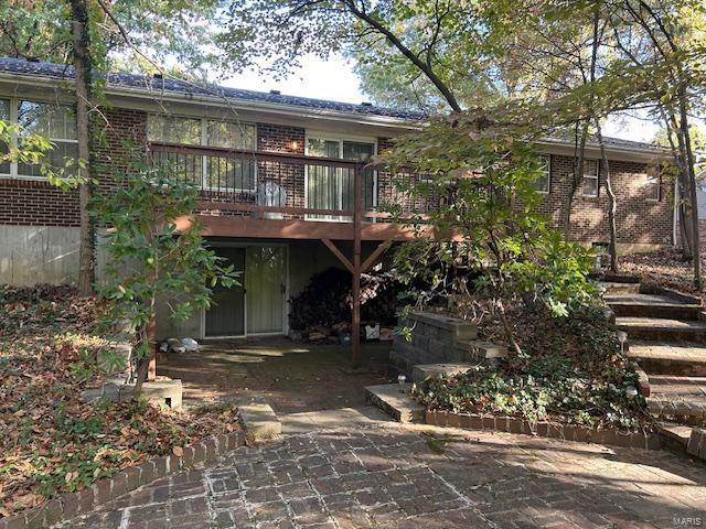 rear view of house featuring a patio area and a wooden deck