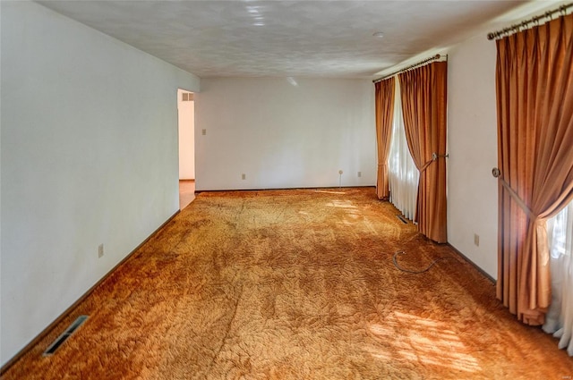 carpeted empty room with a textured ceiling